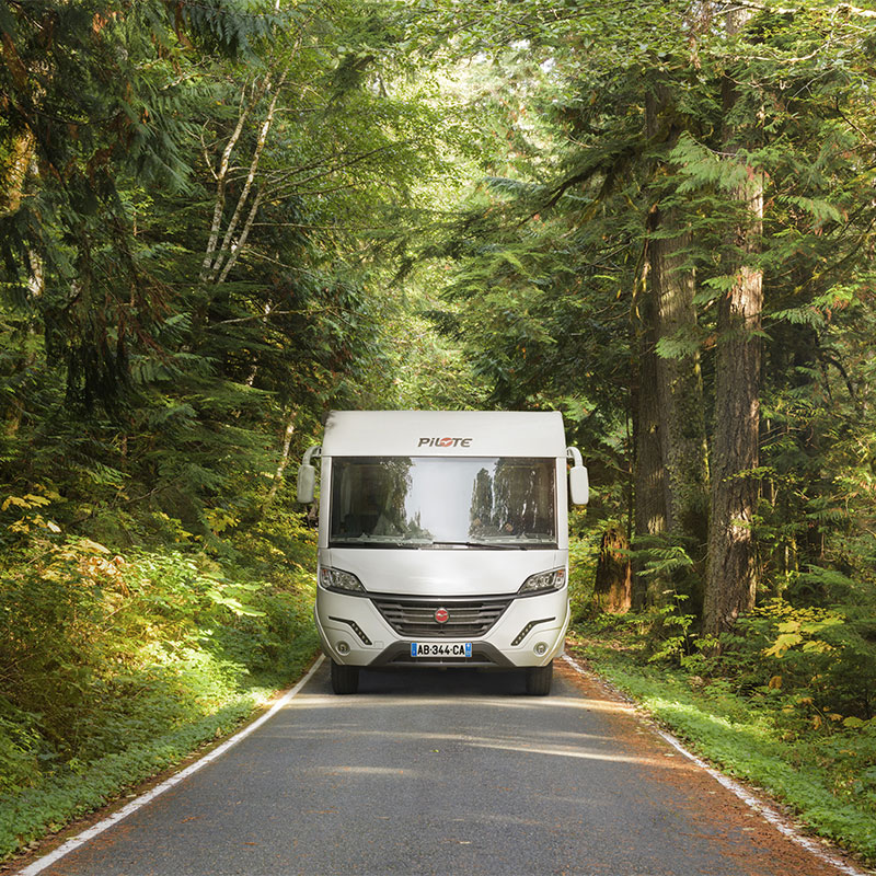 Camping-car intégral Pilote roulant au milieu de la forêt noire.