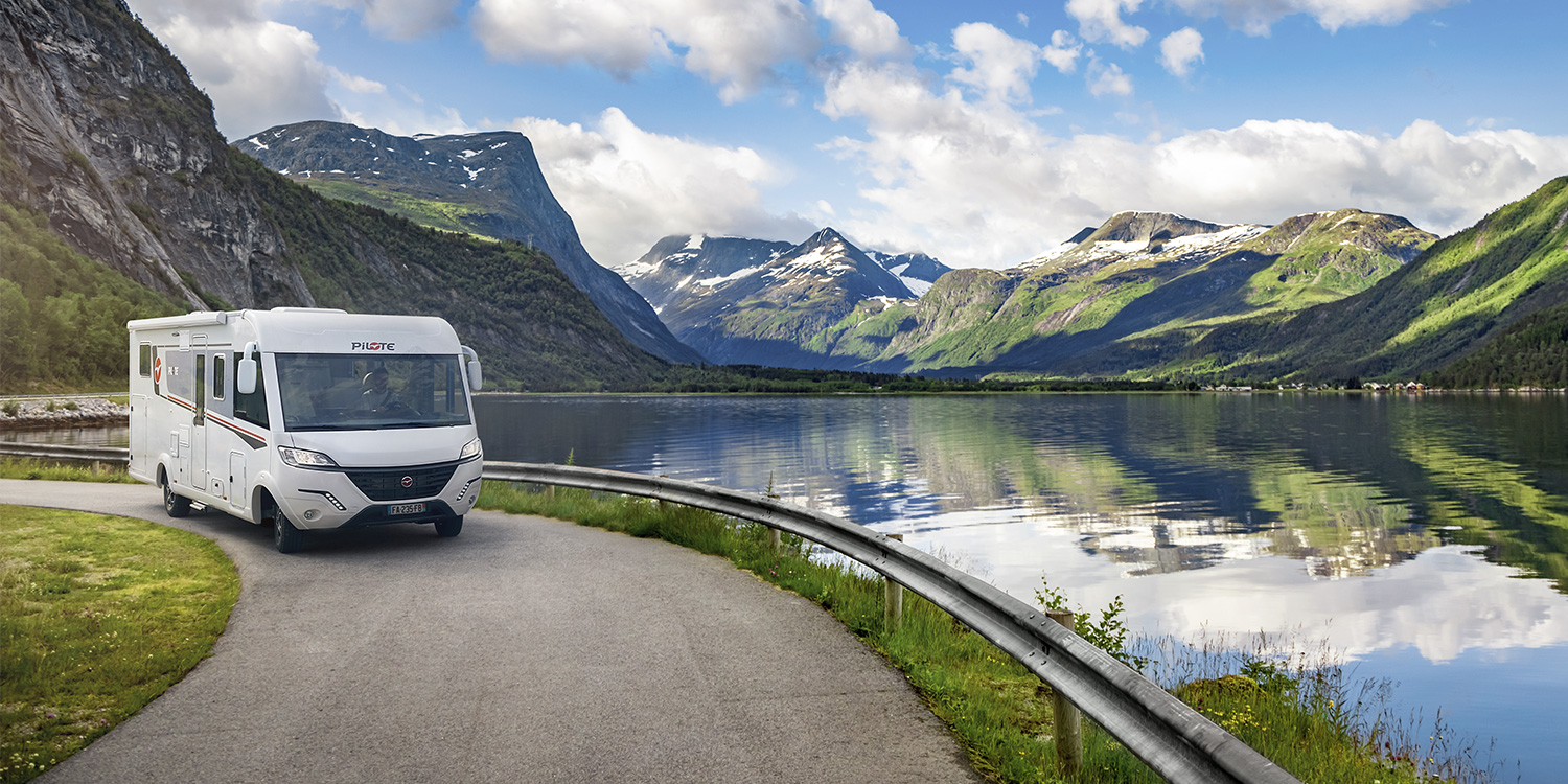 Camping-car intégral Pilote roulant au bord d'un lac de montagne.