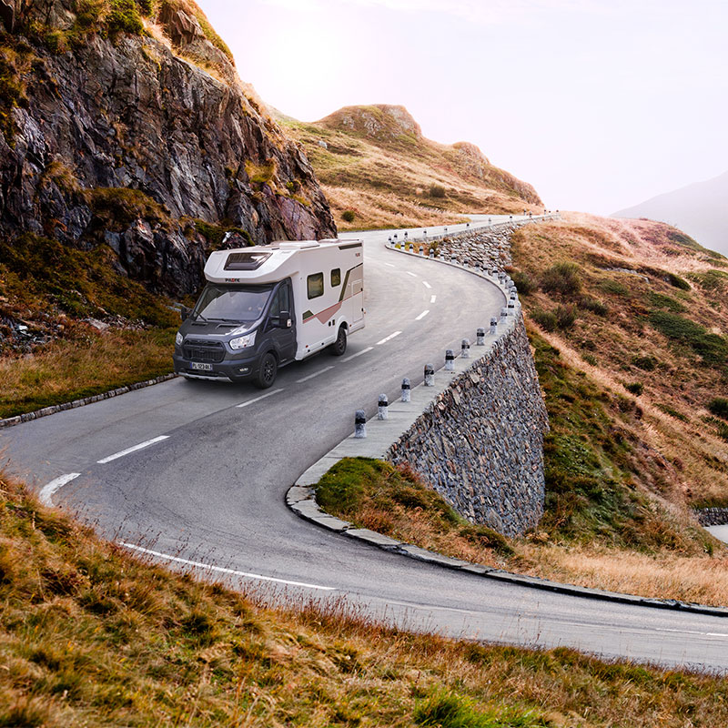 Camping-car profilé étroit Pilote sur une route sinueuse de montagne.