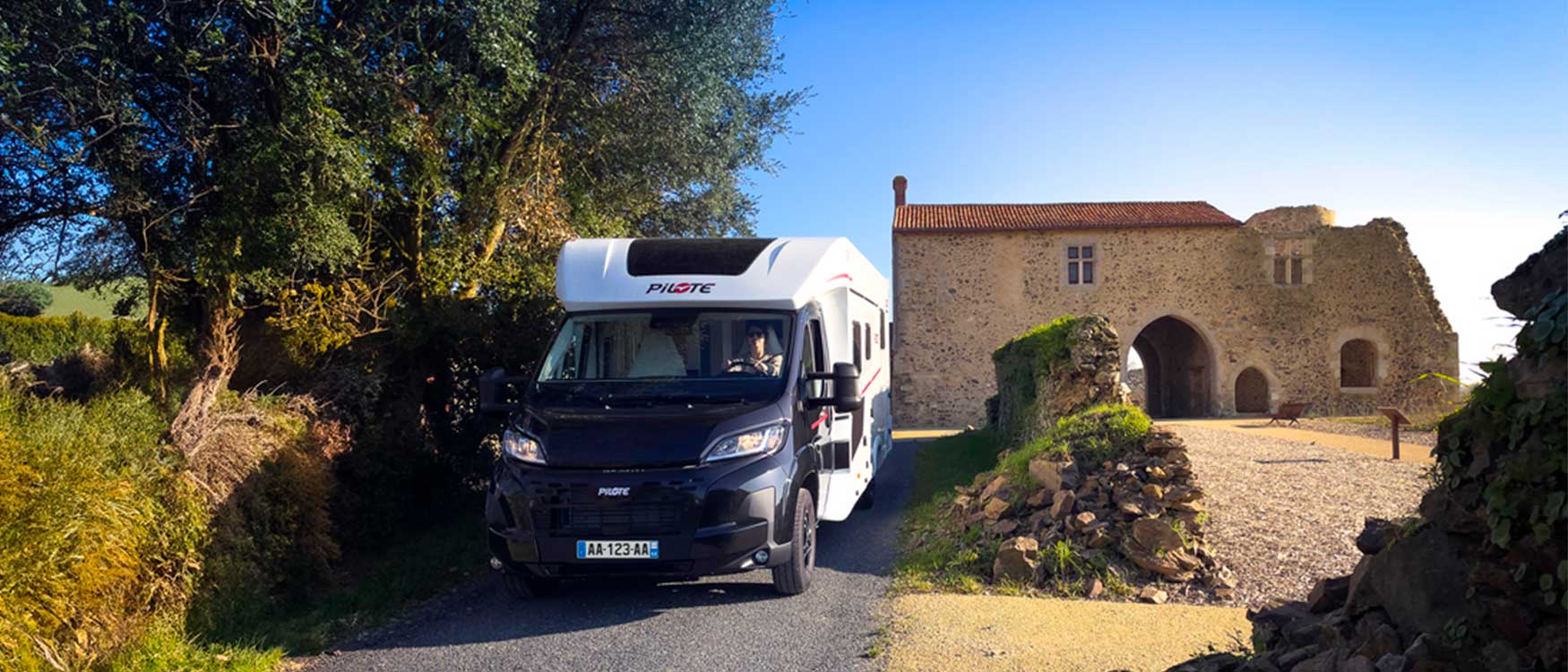 Camping-car profilé P720FC Sélection Pilote vu de face, le long d'une allée.